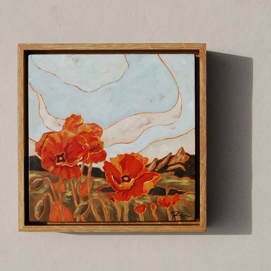 Framed artwork of red flowers on a beige wall